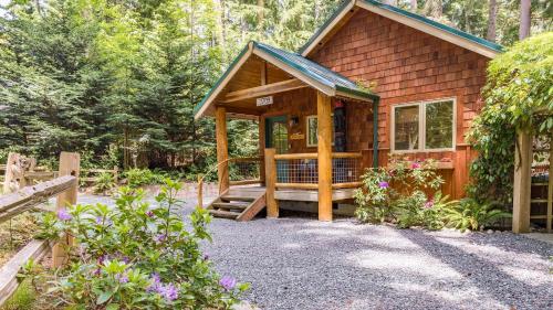 a cabin in the woods with a porch at The Cottage at Herons Roost by AvantStay in Langley