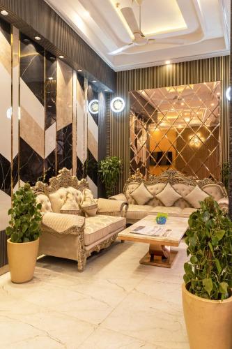 a living room with couches and a table and potted plants at Hotel East End Delhi Aiport in New Delhi