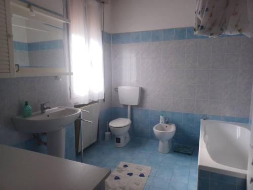 a blue and white bathroom with a sink and a toilet at Casa di Nonna Tamerice! in Berra