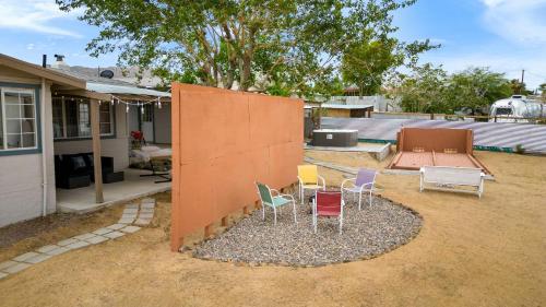a group of chairs sitting outside of a house at Fable by AvantStay 2 Unique Spaces w Bowling Hot Tub Fire Pit Large Yard in Joshua Tree