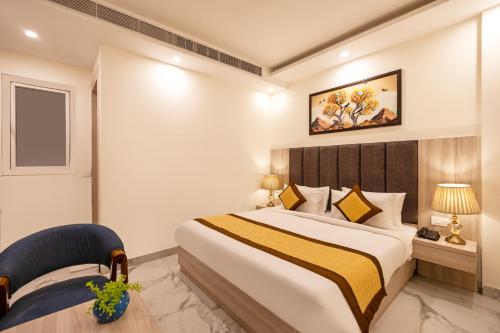 a hotel room with a bed and a chair at Hotel East End Delhi Aiport in New Delhi