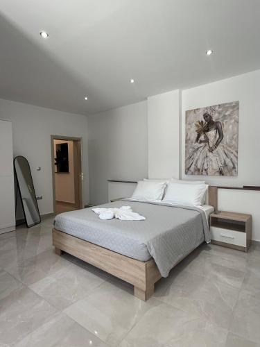 a bedroom with a bed and a painting on the wall at Casa Loma 2 RHODES-FAMILY VILLA,PRIVATE POOL & FARM in Rhodes Town