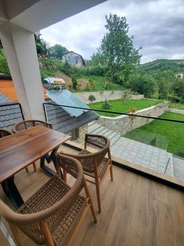 a balcony with a wooden table and chairs and a view at Bujtina Pelion 