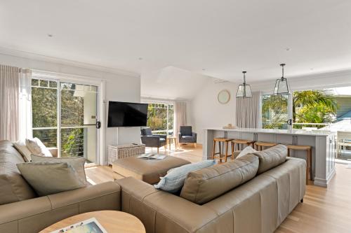 a living room with a couch and a table at Umina Beachside Getaway - Hot Tub - 5 Bedrooms in Umina