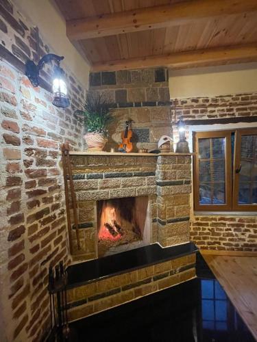 a fireplace in a room with a brick wall at Bujtina Pelion 