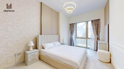 a bedroom with a white bed and a window at Dubai Skyline Balcony Views near Burj Khalifa & Dubai Mall Luxury 2BR - Like Home in Dubai