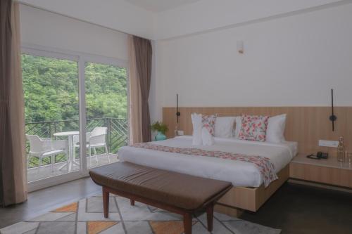 a bedroom with a large bed and a balcony at Simala Retreat Baiguney in Naya Bāzār
