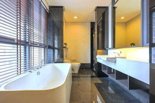 a bathroom with two sinks and a tub and a toilet at The Mews Kuala Lumpur in Kuala Lumpur