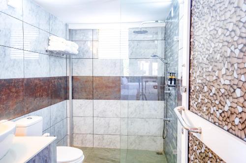 a bathroom with a shower and a toilet at Amara White Villa in Ahungalla
