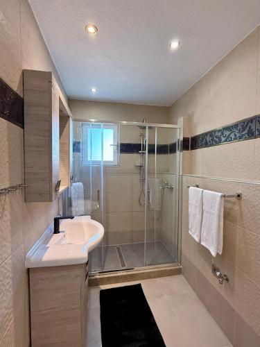 a bathroom with a shower and a sink and a glass shower at Casa Loma 2 RHODES-FAMILY VILLA,PRIVATE POOL & FARM in Rhodes Town