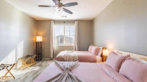 a bedroom with two beds and a ceiling fan at Luxe Indio Stay w Pool Tiki Bar Fire Pit Near Coachella Longfellow in Indio