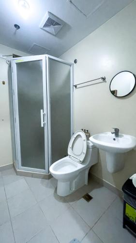 Un baño con ducha, inodoro y lavabo. en G Contemporary 1BR Escape, en Iloilo City