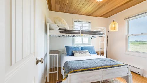 a bedroom with a bunk bed with blue pillows at Swan Lake Cottage by AvantStay Views Firepit in Oak Harbor