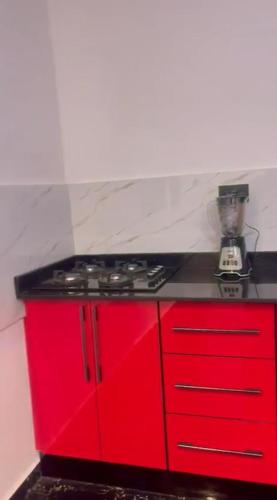 a red kitchen with a stove and red cabinets at Villa Casa in Accra