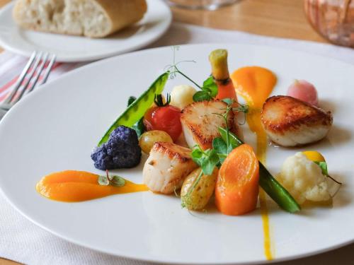 a plate of food with vegetables and fruits on a table at Mercure Saint-Lary in Saint-Lary-Soulan