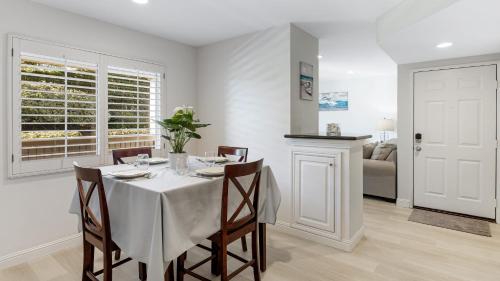 a white dining room with a table and chairs at Walk to Beach Pool Hot Tub Private Patio Parking Seabreeze Retreat in Dana Point