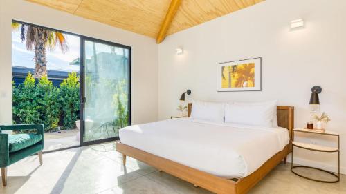 a bedroom with a bed and a large window at Blackhaus A Buyout by AvantStay 4-Room Retreat in Palm Springs