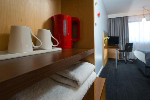 a hotel room with a desk with towels and a red appliance at Holiday Inn Express Stevenage by IHG in Stevenage