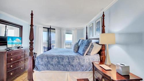 a bedroom with a bed and a dresser and a television at 504 Summerhouse by AvantStay Ocean Front Condo w Community Pool Access in Isle of Palms