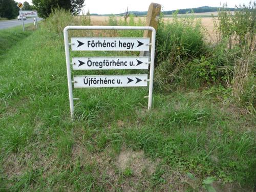 a sign in the grass with arrows on a road at Förhénc Wine House & Guesthouses I-II-III in Nagykanizsa