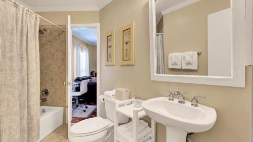 a white bathroom with a toilet and a sink at 504 Summerhouse by AvantStay Ocean Front Condo w Community Pool Access in Isle of Palms