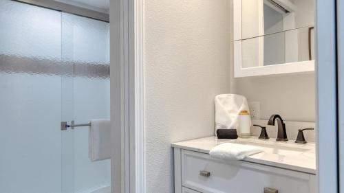 ein weißes Badezimmer mit Waschbecken und Spiegel in der Unterkunft Cozy 2BR Fawnskin Cabin Big Bear Lake Hiking Trails Snow Summit Nearby in Fawnskin