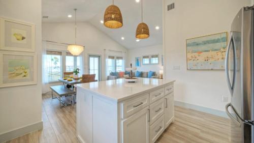a kitchen with a refrigerator and a dining room at Casa Rita by AvantStay Snowbird Discounted Rates Private Pool Near Beach in Port Aransas