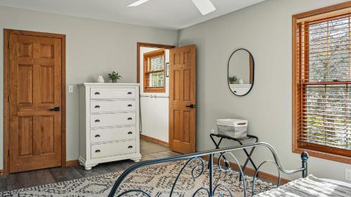 a bedroom with a bed and a dresser and a mirror at Lakers Pointe by AvantStay Lakefront Private Peninsula Hot Tub Game Room in Long Pond
