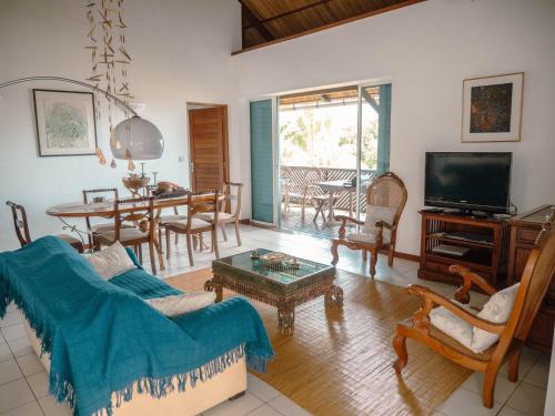 a living room with a couch and a tv and a table at Canopy House in Tamarin