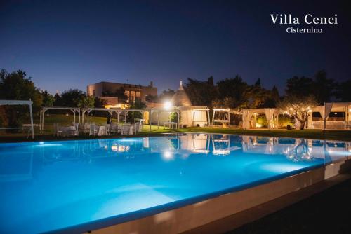 a large blue swimming pool at night at Relais Masseria Villa Cenci in Cisternino