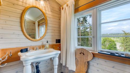 a bathroom with a sink and a mirror at Maxwelton Aerie Bluffside Retreat w Sweeping Puget Sound Views Firepit in Clinton
