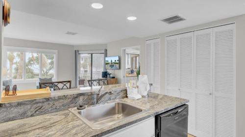 a kitchen with a sink and a counter top at 202 D Port O Call by AvantStay Beach Condo in Isle of Palms