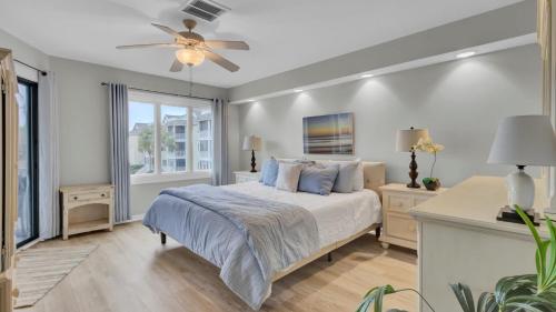 a bedroom with a bed and a ceiling fan at 202 D Port O Call by AvantStay Beach Condo in Isle of Palms