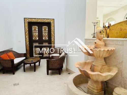 a living room with a fountain in the middle of a room at Dar kmar in Tunis
