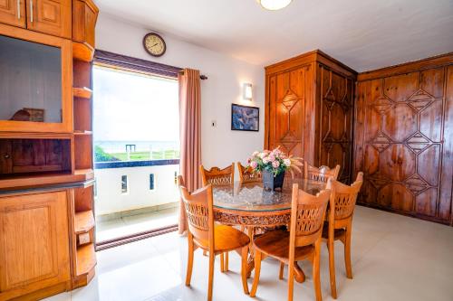 a dining room with a table and chairs and a window at Amara White Villa in Ahungalla