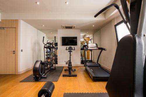 a gym with treadmills and machines in a room at Zenit Abeba in Madrid