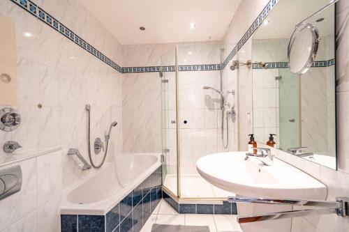 ein Badezimmer mit Badewanne, Waschbecken und Dusche in der Unterkunft City Wohnung am Hbf mit 2 Schlafzimmern und Sky in Koblenz