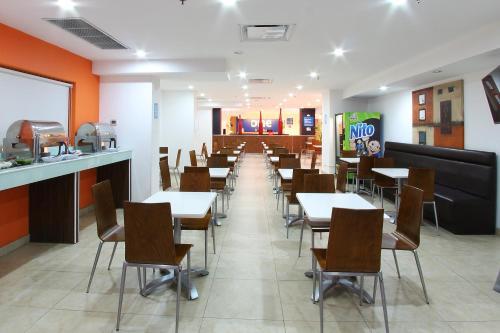 a dining room with tables and chairs in a restaurant at One Guadalajara Centro Historico in Guadalajara