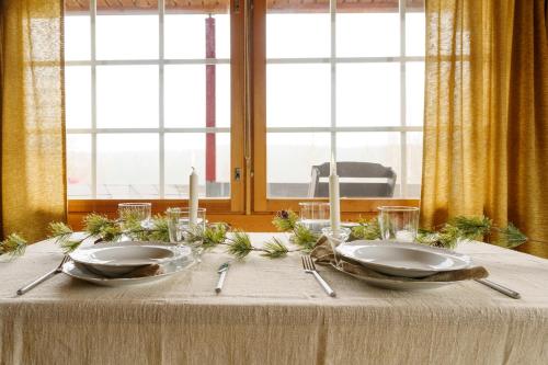 un tavolo con due piatti e candele sopra di Frosty Brook Cottage Hosted by Hygge Host a Lehtola