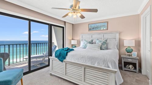 a bedroom with a bed and a balcony with the ocean at Beachfront Breeze by AvantStay Beachfront Condo in Panama City Beach