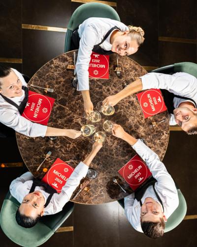 a group of people sitting around a table with wine glasses at Hilton Rijeka Costabella Beach Resort And Spa in Rijeka