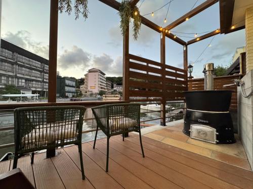 two chairs and a grill on a deck with a view at UMI&kanzanji in Hamamatsu