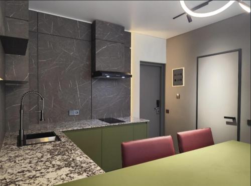 Una cocina con fregadero y una mesa con sillas. en XO Canggu adults only, en Canggu