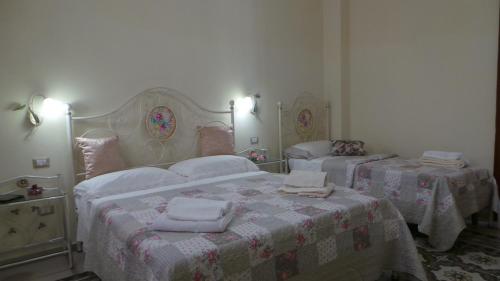 een slaapkamer met 2 bedden met dekens en handdoeken bij Oasi Ottocento in Quartu SantʼElena