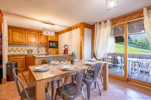a dining room with a table and chairs and a kitchen at Fermes de Méribel #D13 - 6 guests - Ski in - Ski out in Chandon
