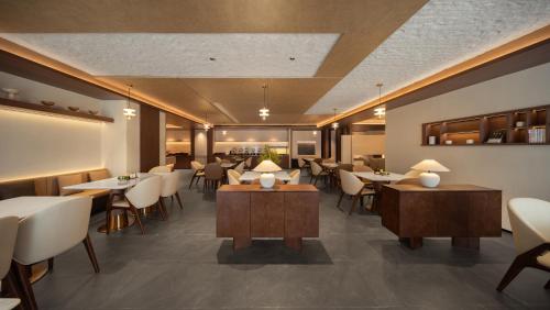 a restaurant with tables and chairs in a room at Atour Hotel Pengbo Central Plaza Lanzhou Zhongchuan Airport in Lanzhou