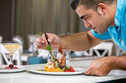 a man sitting at a table with a plate of food at Wind of Lara Hotel & SPA - All Inclusive in Lara