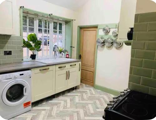 a kitchen with a washer and dryer in a room at The Hideaway in Sutton Scotney