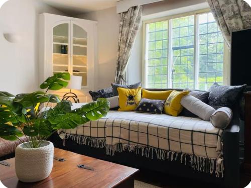 a living room with a couch with yellow pillows at The Hideaway in Sutton Scotney