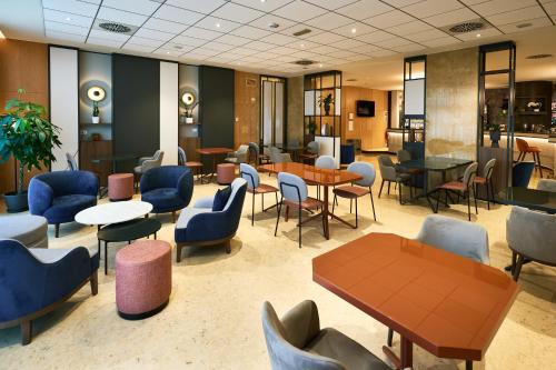 a waiting room with tables and chairs and tablesktop at Crowne Plaza Padova by IHG in Padova